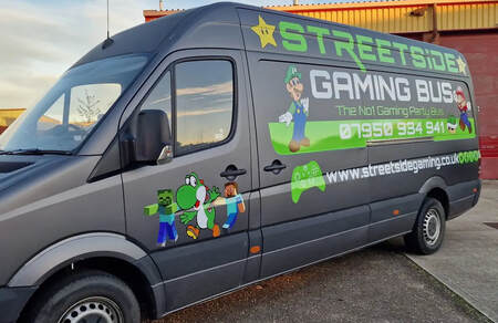 An inviting gaming Van interior equipped with multiple screens, colorful led lights, and cozy green seating, ready for a fun multiplayer video game session.14players