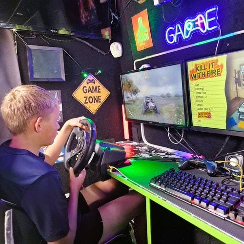 Child using the racing simulator inside the Streetside Gaming Bus in Chantry, Suffolk