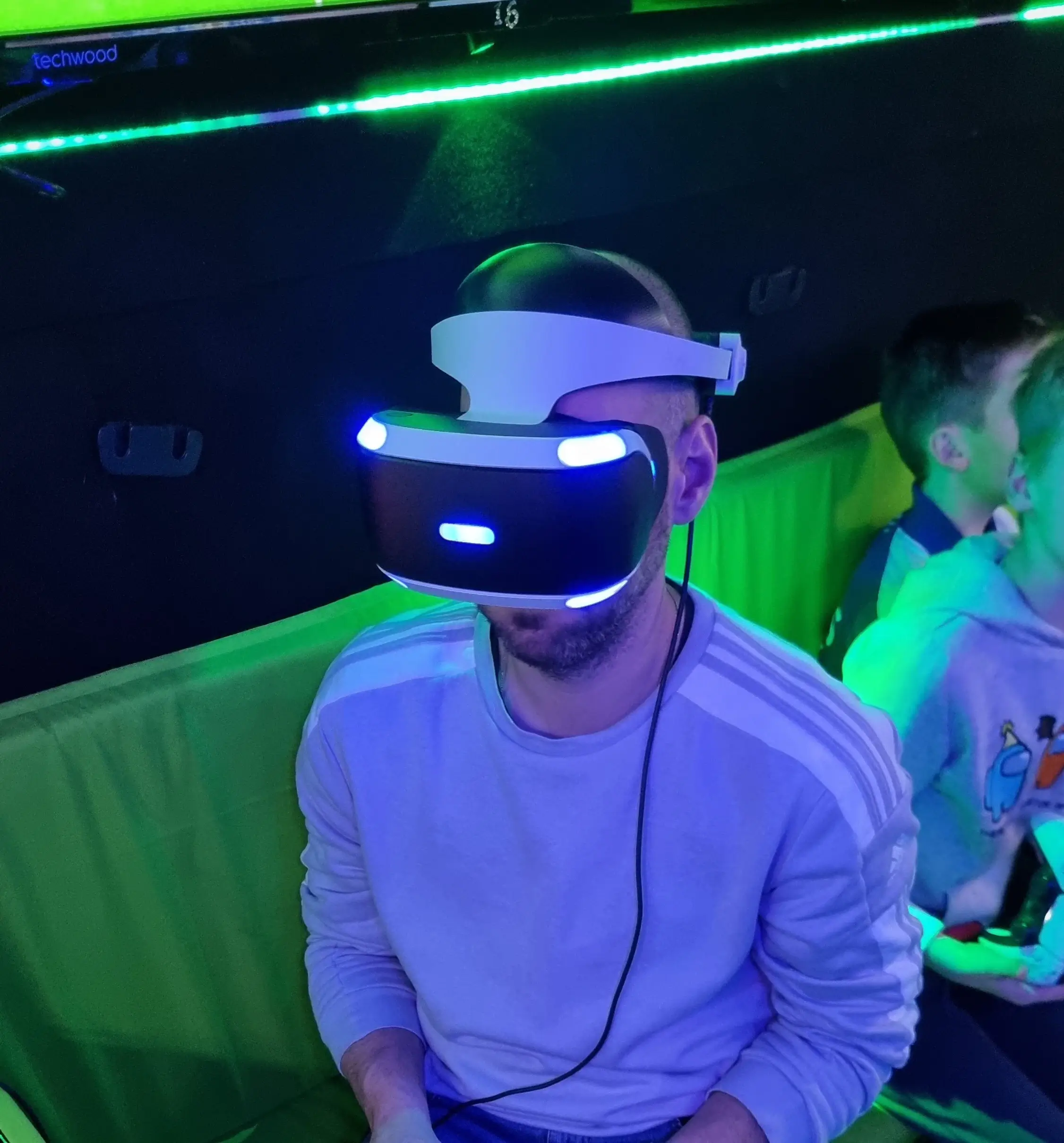 Adult wearing a virtual reality headset inside the Streetside Gaming Bus.
