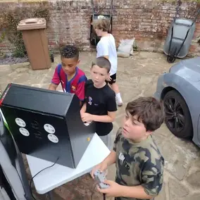 Children playing an outdoor retro arcade game at a Streetside gaming party