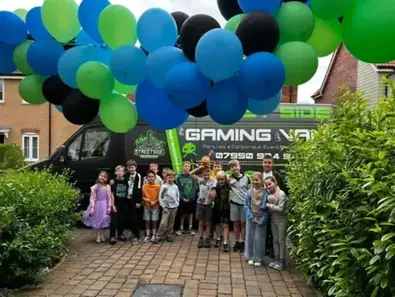 Children celebrating beside the Streetside Gaming Bus at a birthday party in Colchester
