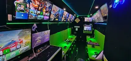 Inside the Streetside Gaming Bus in Danbury with racing simulator, green seating and multiple gaming screens