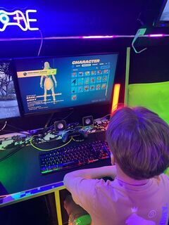 Child choosing a Fortnite character inside the Streetside Gaming Bus during an Easter gaming party
