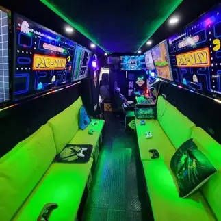 Inside the Streetside Gaming Bus in Brightlingsea with neon-green seating and retro Pac-Man gaming displays