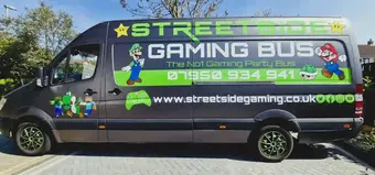 Exterior side view of the Street Side Gaming Bus parked in Witham featuring a custom Mario and Luigi vinyl wrap