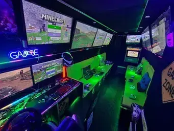 Special offers inside the Streetside Gaming Bus in Essex and Suffolk with green seating, gaming PC and multiple screens