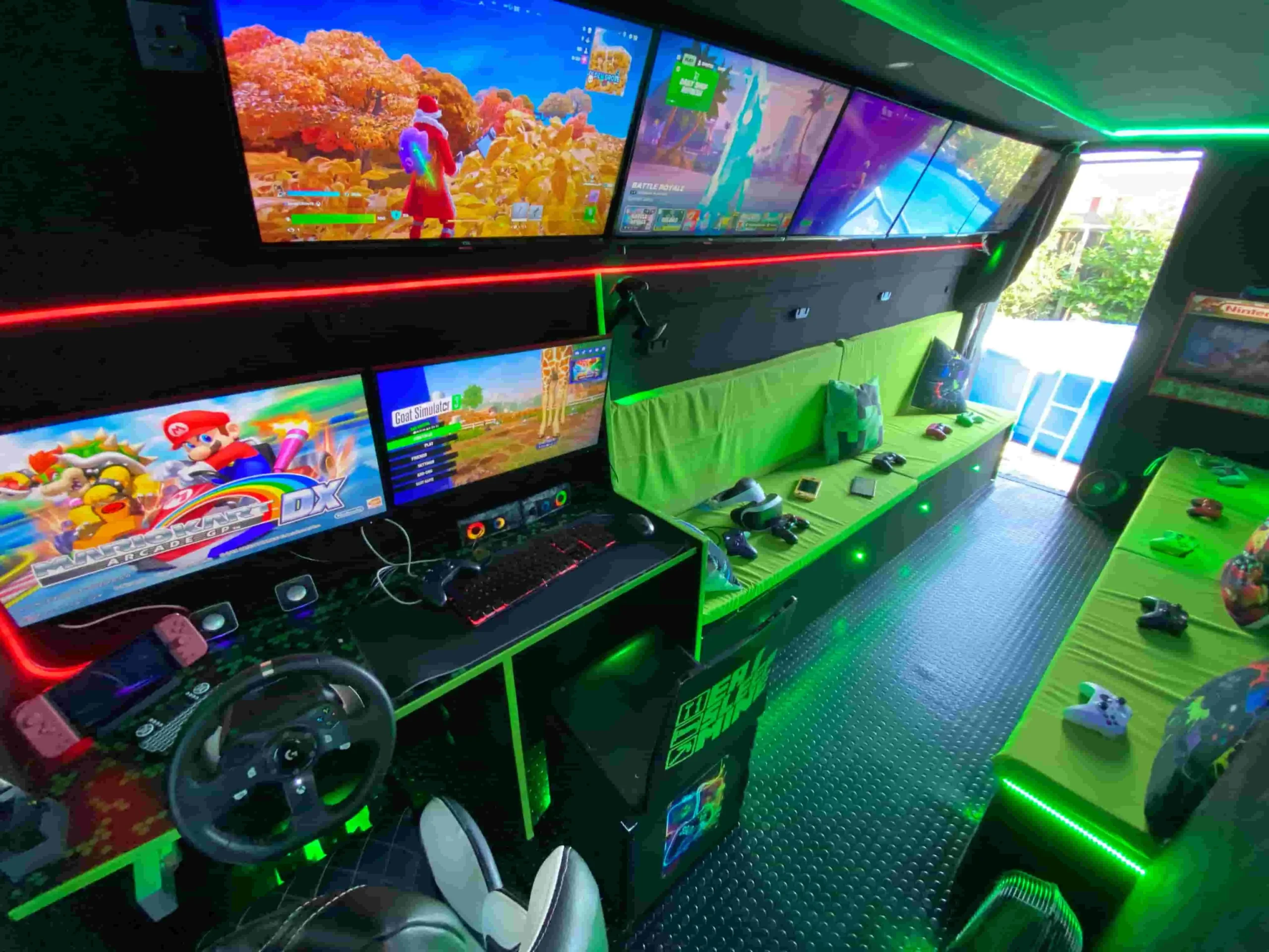 Interior wide shot of a mobile gaming bus in Witham featuring neon green lighting, multiple TV screens, and a racing simulator