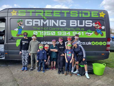Children standing beside the Streetside Gaming Bus at a birthday party in Great Dunmow