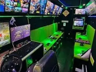 Inside the Streetside Gaming Bus in Manningtree with a racing simulator, green seating and multiple gaming screens