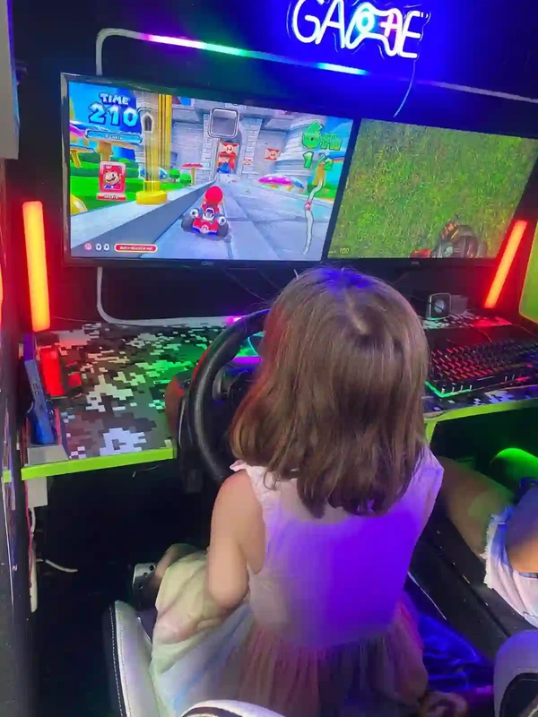 Child playing Mario Kart on the racing simulator inside the Streetside Gaming Bus in Great Dunmow