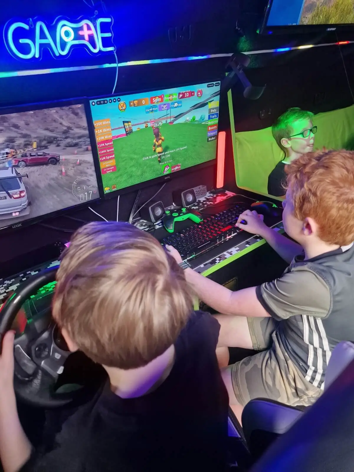 Children playing on the racing simulator and gaming PC inside the Streetside Gaming Bus.