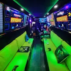 Inside the Streetside Gaming Bus with neon-green seating, Xbox controllers and multiple gaming screens