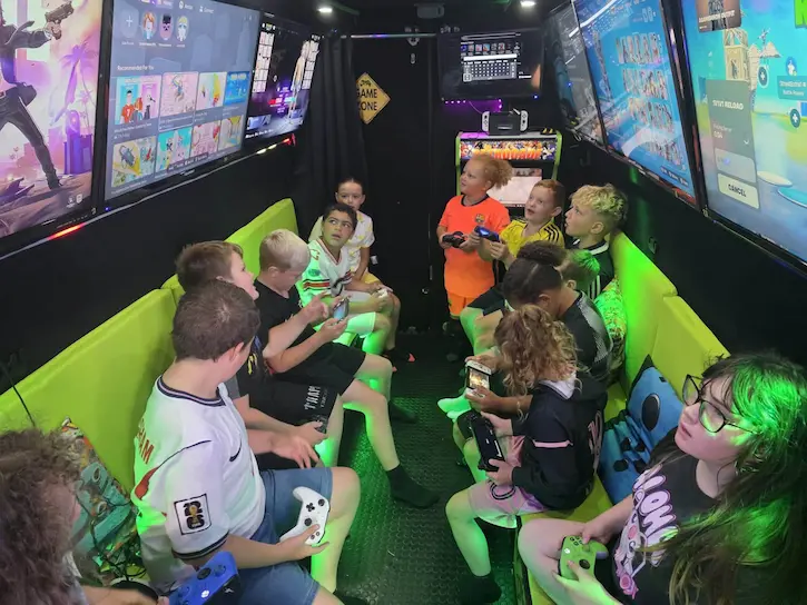 Children enjoying a HAF gaming session with Thrive inside the Streetside Gaming Bus.