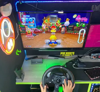 Child playing Mario Kart on a racing simulator inside the Streetside Gaming Bus during a HAF holiday activity session.